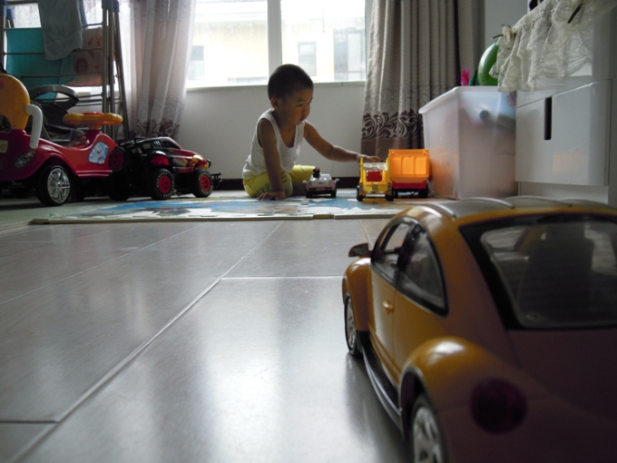 上午9：00，大峻熙自己坐在爬行垫上玩汽车。